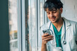 © carballo - doctor in uniform with stethoscope at window with mobile phone