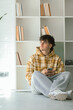 © carballo - young man with mobile phone at home in casual outfit