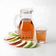 © Fernando Sanso - Jarra e copo com suco de maçã fresco e fatias da fruta em fundo claro. Bebida natural e saudável para o café da manhã ou lanche nutritivo.