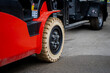 © K - Red industrial forklift with beige solid tire and steel rim operating on concrete surface showing durable construction, load-bearing design, and precision engineering for warehouse use