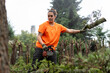 © CatalnIlie - Woman arborist working with chainsaw, removing branches, clearing forest area for renovation or maintenance