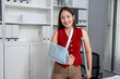 © Kawee - Portrait of injured Asian businesswoman wearing hand splint in office.