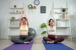 © Kawee - Asian two pregnant women doing yoga workout in living room at home.