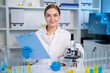 © Kawee - Portrait of Caucasian female scientist in white lab coat in laboratory.
