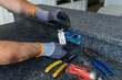 © Andrei Liashchou - Electrician replacing GFCI outlet on black kitchen island countertop, Florida, USA