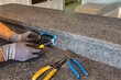 © Andrei Liashchou - Electrician installing black GFCI outlet on granite kitchen island, Florida, USA
