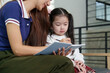© itchaznong - Mother and Daughter Learning Together. A mother guides her daughter in writing.