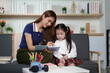 © itchaznong - Creative Learning Moment. A mother and daughter engage in writing activities at home.