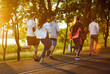 © Studio Romantic - Rear view of a team of people running at sunset, engaging in group jogging, boosting sport training, uniting as runners, enhancing workout effort in a scenic outdoor fitness setting.