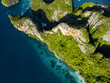 © AmazingAerialAgency - Aerial view of vibrant green foliage contrasts with the rugged cliffs and turquoise waters of Phi Phi Islands, Krabi, Thailand.