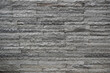 © Okta - A full-frame background of a grey stacked stone wall. The rough texture of the natural granite bricks creates a strong, decorative pattern.