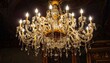 © kangen - Ornate crystal chandelier with multiple glowing lightbulbs, elegant decor