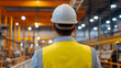 © photo for everything - An engineering worker in hardhat with reflective vest is standing in a facility and looking at the production line. The employee checks if everything is okay. #engineer #production