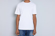 © New Africa - Man wearing white t-shirt on light grey background, closeup. Mockup for design