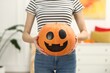 © New Africa - Happy Halloween. Woman with Jack-o'-lantern pumpkin at home, closeup
