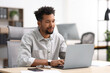 © New Africa - Man working on laptop at table in office