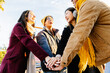 © Xavier Lorenzo - Cheerful young students joining hands in unity, enjoying the winter season outdoors while laughing and celebrating their friendship