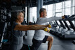 © Nomad_Soul - Elderly man and woman are doing squats with dumbbells in a gym