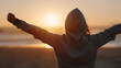 © Muhammad - Hooded Figure with Outstretched Arms Silhouetted Against Golden Sunset, Embracing Freedom and Hope
