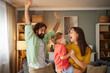 © Stockphotodirectors - Family members share laughter and excitement at home, where they are playing together. The warm living room is filled with joy as they celebrate this special time.