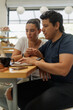 © Gener Vázquez - Hispanic Couple Working on Laptop in a Bakery