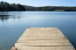 © qrrr - Drewniany pomost nad dużym jeziorem o błękitnej wodzie