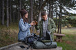 © Miljan Živković - Happy couple camping, toasting beer bottles in forest