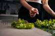 © dikushin - Cropped shot of female chef preparing fresh, homegrown green lettuce on cutting board, highlighting importance of healthy eating and embracing farm-to-table practices for nutritious meals.