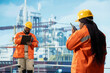 © DC Studio - Drilling barge engineer uses two way radio to communicate with logistics crew coworkers. Offshore platform professional talking in walkie talkie providing audio clarity in noisy environment