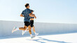 © muse studio - Couple jogging on a rooftop with clear blue sky in a city
