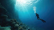 © Vadym - Diver with full scuba gear explores vast deep blue ocean. Bright sun rays penetrate clear water above rich coral reef. Many small fish swim in large schools near reef wall. Underwater adventure shows