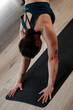 © Nikola Spasenoski - Woman practicing yoga in an indoor studio during a morning class focusing on flexibility and strength with a calm and serene ambiance
