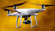 © Grit - White drone hovers gracefully against yellow backdrop, embodying technological prowess and aerial freedom with quiet confidence