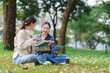 © crizzystudio - Young women studying together on campus grass