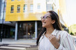 © Westend61 - Smiling woman with glasses outdoors in urban city enjoying the day