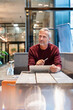 © Westend61 - Business portrait of thoughtful man working with tablet in modern office