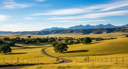  Scenic rural landscape with winding path and mountain range under blue sky