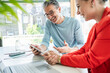 © Westend61 - Happy mature businessman discussing strategy with businesswoman over tablet PC