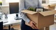 © Adwan - Employee carrying box of personal items, leaving office