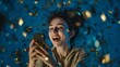 © Rifqi - Excited young woman using smartphone under falling gold confetti against blue backdrop, concept for celebration announcement, online communication and success marketing
