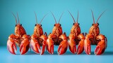 A row of five orange crustaceans with claws against a light blue background