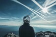 © Panuwat - Person standing top mountain looking up sky is Chemtrail conspiracy theory concept