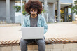 © ADDICTIVE STOCK - Man using laptop in urban setting outdoors