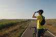 © ADDICTIVE STOCK - Cyclist pauses on rural path in Northern France under blue sky