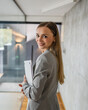 © Miljan Živković - Confident businesswoman walking through modern office building holding laptop
