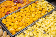 Three trays of beautifully arranged sliced fruit sit on a table