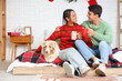 © Pixel-Shot - Happy young couple with cocoa and dog in bedroom on Christmas eve