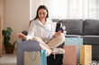 © Pixel-Shot - Young woman with mobile phone and credit cards sitting among shopping bags at home. Black Friday sale