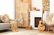 © Pixel-Shot - Interior of living room with sofa, armchair, closet, guitar, fireplace and autumn home decor near white wall