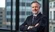 © Cherrin - Portrait of a handsome business leader. Confident businessman posing in a modern office with cityscape backdrop.